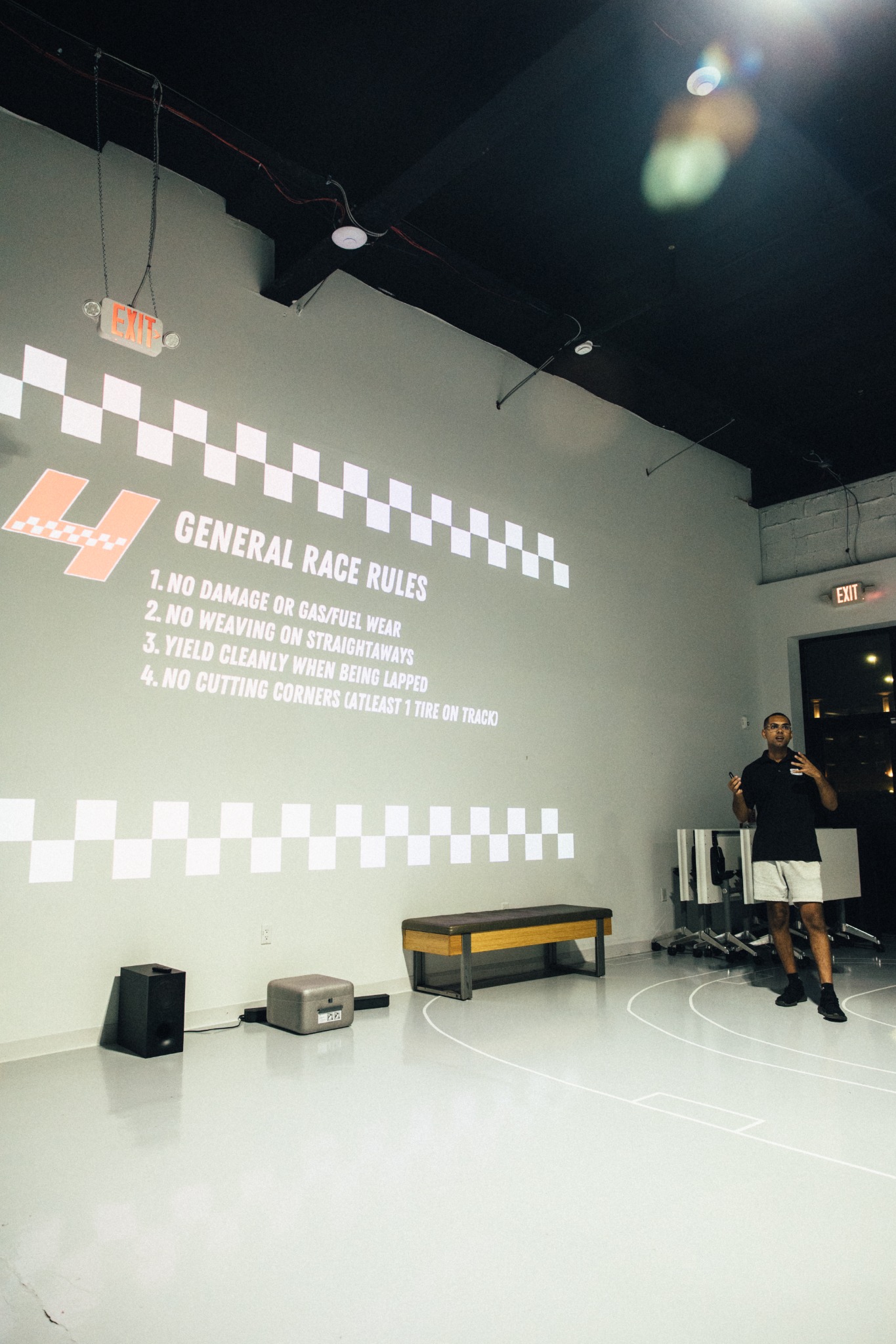 SIM1 Racing general race rules projected on a wall during the pre-race briefing.