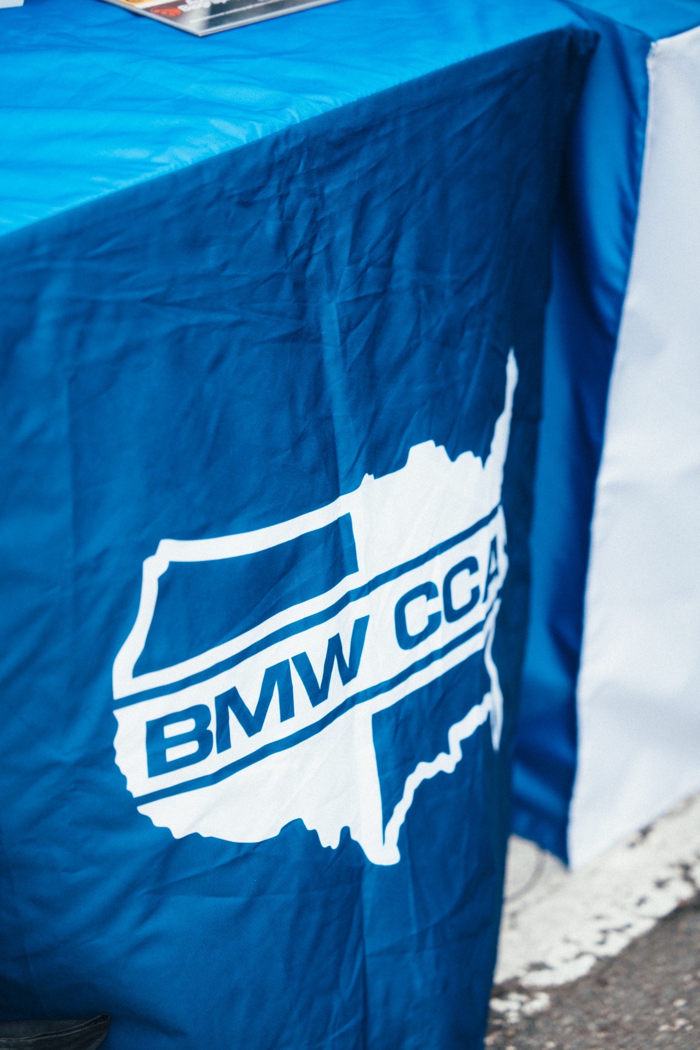 Close view of a blue BMW CCA USA banner at the outreach display.